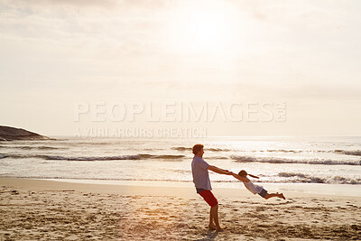 Buy stock photo Outdoor, father and child on beach for swing, playful and bonding together on vacation holiday. Space, family and papa with girl for security, connection and air game with sunset by sand in ocean