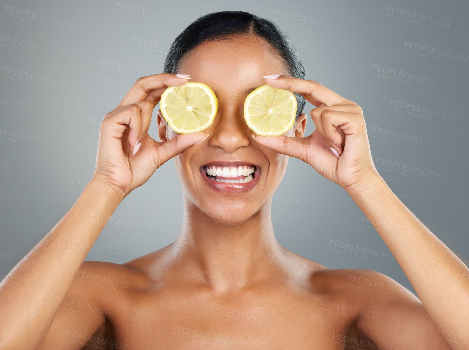 Buy stock photo Happy woman, lemon and skincare with fruit for vitamin C, skincare or natural cosmetics on a gray studio background. Young, female person or model with smile for organic citrus, detox or antioxidant