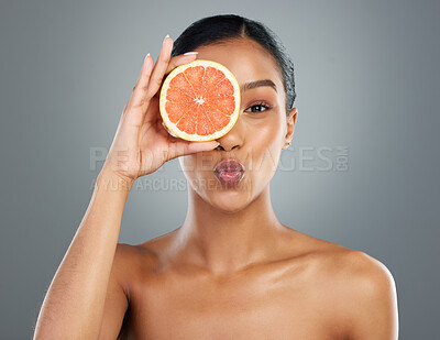 Buy stock photo Happy woman, portrait and skincare with grapefruit for collagen or natural vitamin C on a gray studio background. Young, female person or model with smile for organic fruit, detox or antioxidant