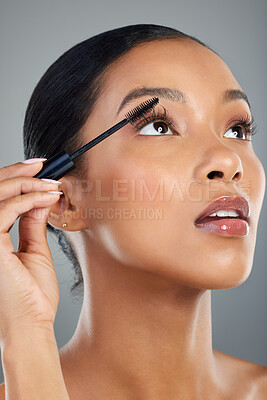 Buy stock photo Woman, cosmetics or eyelashes with mascara or brush for makeup, beauty or facial on a gray studio background. Young, female person or model with equipment, utensil or tool for volume, glow or contour