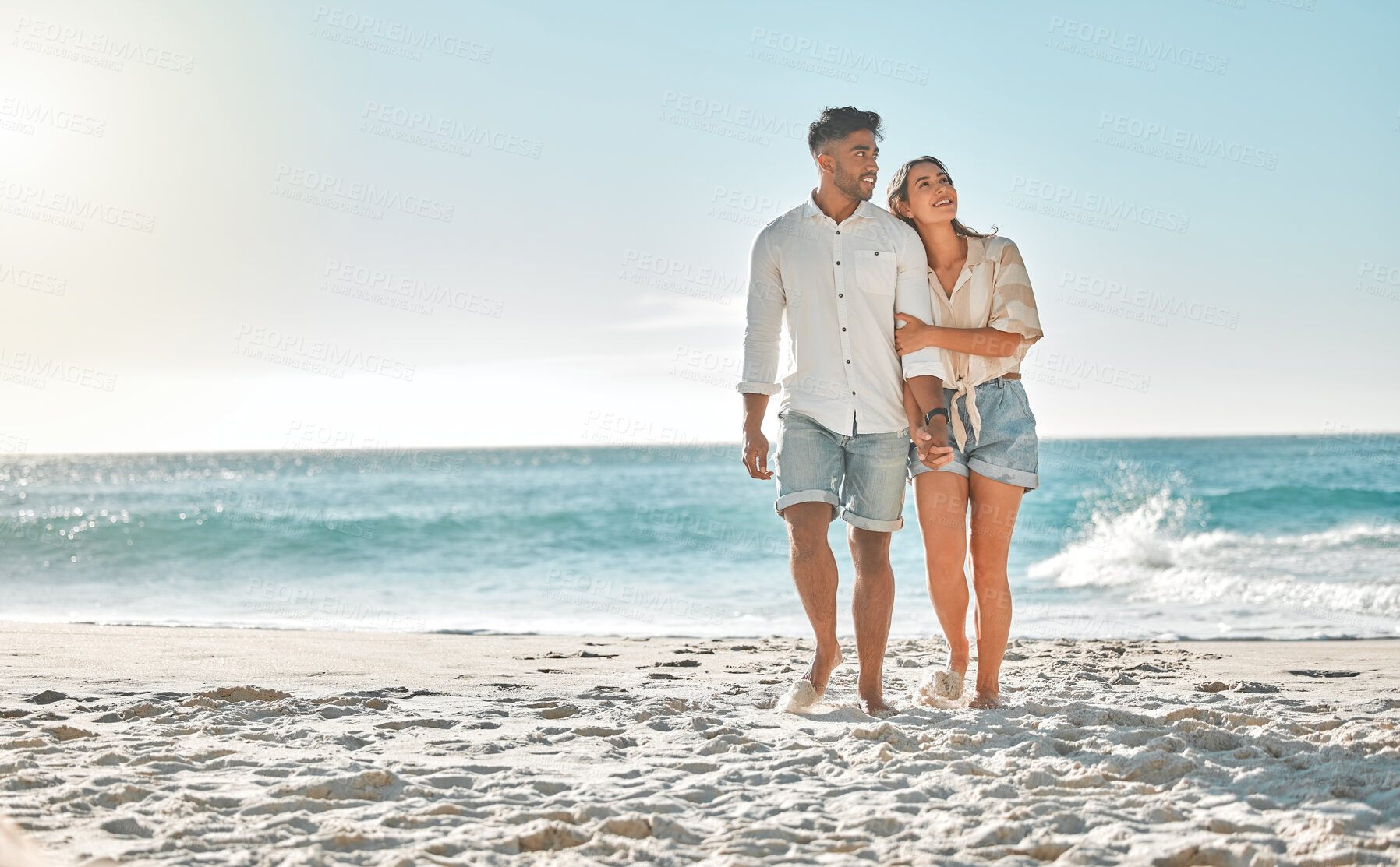 Buy stock photo Shot of a young couple spending time together at the beach