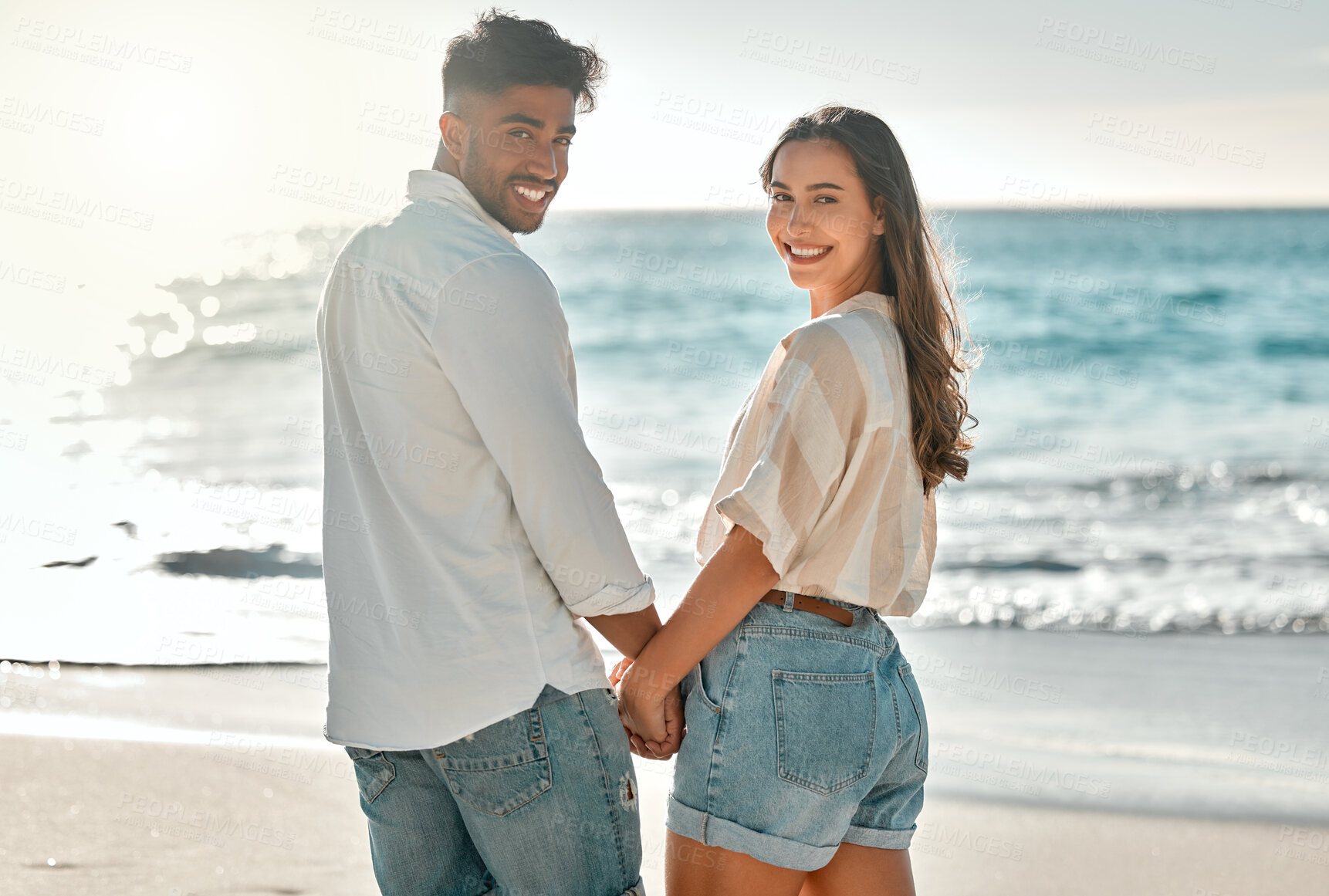 Buy stock photo Portrait, honeymoon or happy couple at sea holding hands for love on vacation, anniversary or holiday. Smile, trust or people at beach for bonding together for travel or ocean trip adventure in Spain