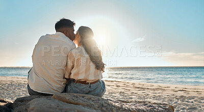 Buy stock photo Shot of a young couple kissing while spending a day at the beach