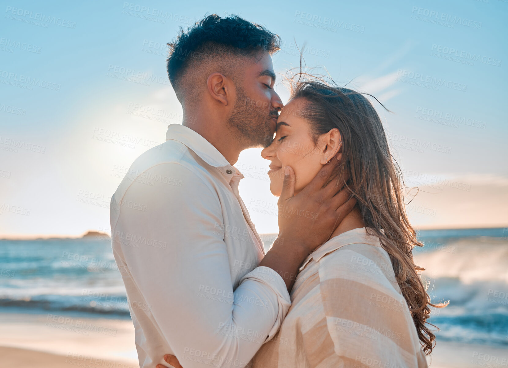 Buy stock photo Kiss, beach and couple hugging on holiday, getaway or vacation for romance together with care. Love, travel and young man and woman embracing by tropical ocean on date on seaside summer weekend trip.