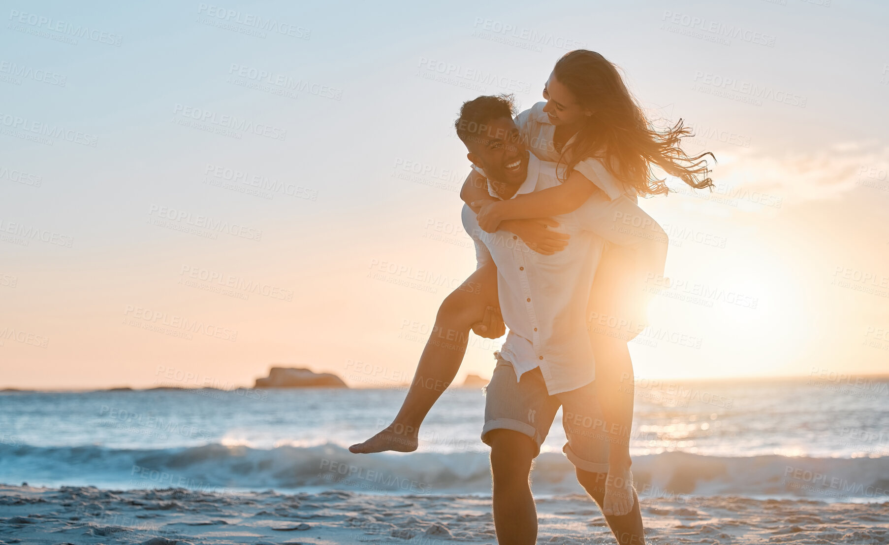 Buy stock photo Shot of a young couple spending time together at the beach