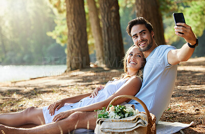 Buy stock photo Couple, relax and smile for picnic selfie in the forest on holiday break or romantic summer vacation together. Happy man and woman relaxing or smiling on mat for photo, memory or date in nature