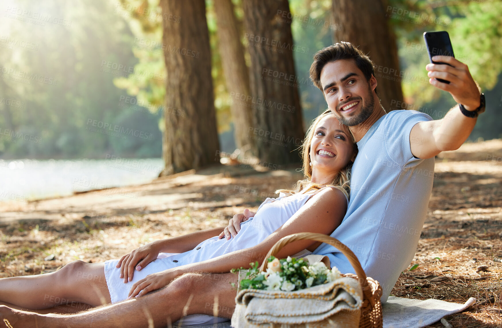 Buy stock photo Couple, relax and smile for picnic selfie in the forest on holiday break or romantic summer vacation together. Happy man and woman relaxing or smiling on mat for photo, memory or date in nature