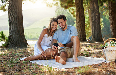 Buy stock photo Couple on picnic, phone and relax together in nature, happy people with social media, travel with bonding outdoor. Happiness, man and woman, communication with trust and love in relationship