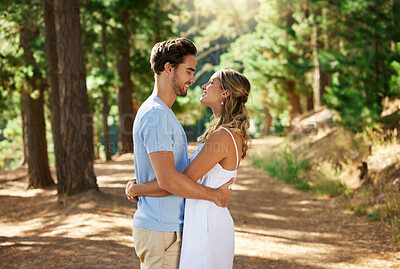 Buy stock photo Happy couple, hug and outdoor forest road of young people showing love for engagement announcement. Woods, trees and care of a woman and man together on holiday in nature with a smile and happiness