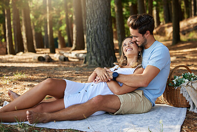 Buy stock photo Couple on picnic, cuddle and happy relationship with love and trust, travel and adventure in nature park. Young people in forest, outdoor and happiness together with smile, commitment and care 
