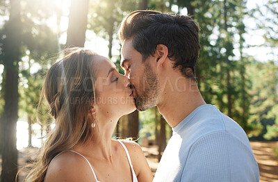 Buy stock photo Couple kiss in forest, love and summer with freedom and adventure, affection in relationship and care outdoor. People together in nature park, commitment and trust with romance, content and sunshine
