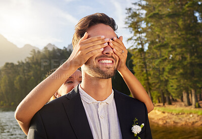 Buy stock photo Love, wedding or surprise with a bride and groom by a lake, in celebration of a ceremony of tradition. Romance, marriage and hands over face with a married couple playing or joking together outdoor