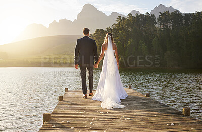Buy stock photo Rearview shot of an unrecognizable bride and groom outside on their wedding day