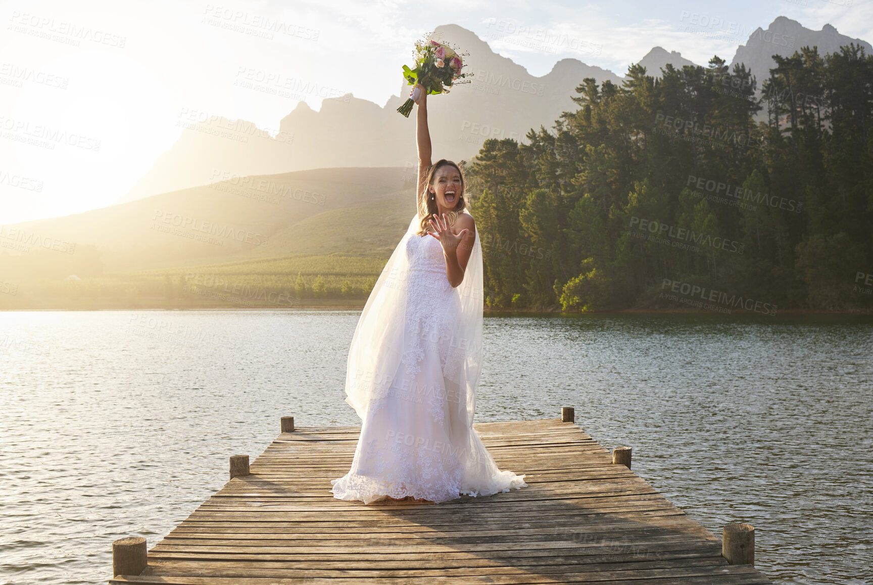 Buy stock photo Wedding, bouquet and celebration with a bride on a pier over a lake in nature after a marriage ceremony. Happy, smile and flowers with a woman celebrating being married in the tradition of matrimony