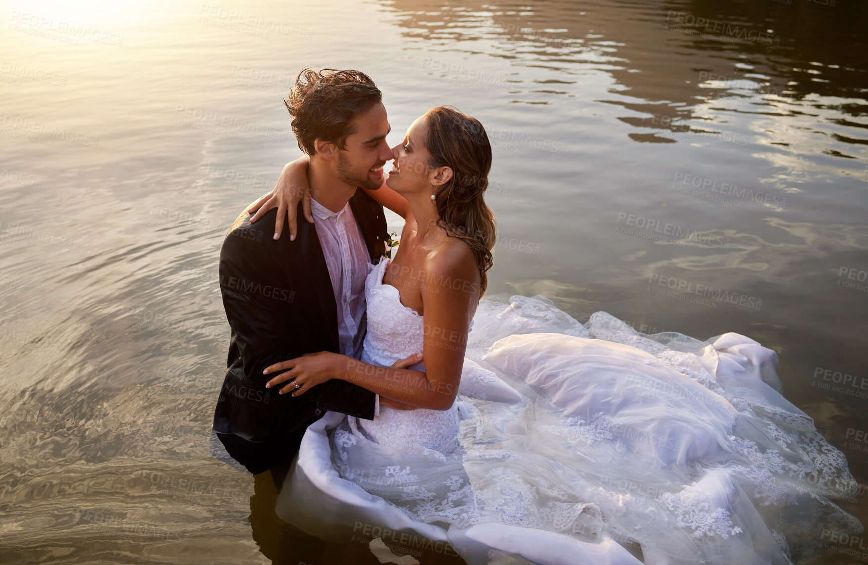 Buy stock photo Wedding, water and wet bride with groom hug, kiss and standing in lake together with passion, smile and romance. Love, marriage and happy couple celebrate romantic, loving relationship in nature.