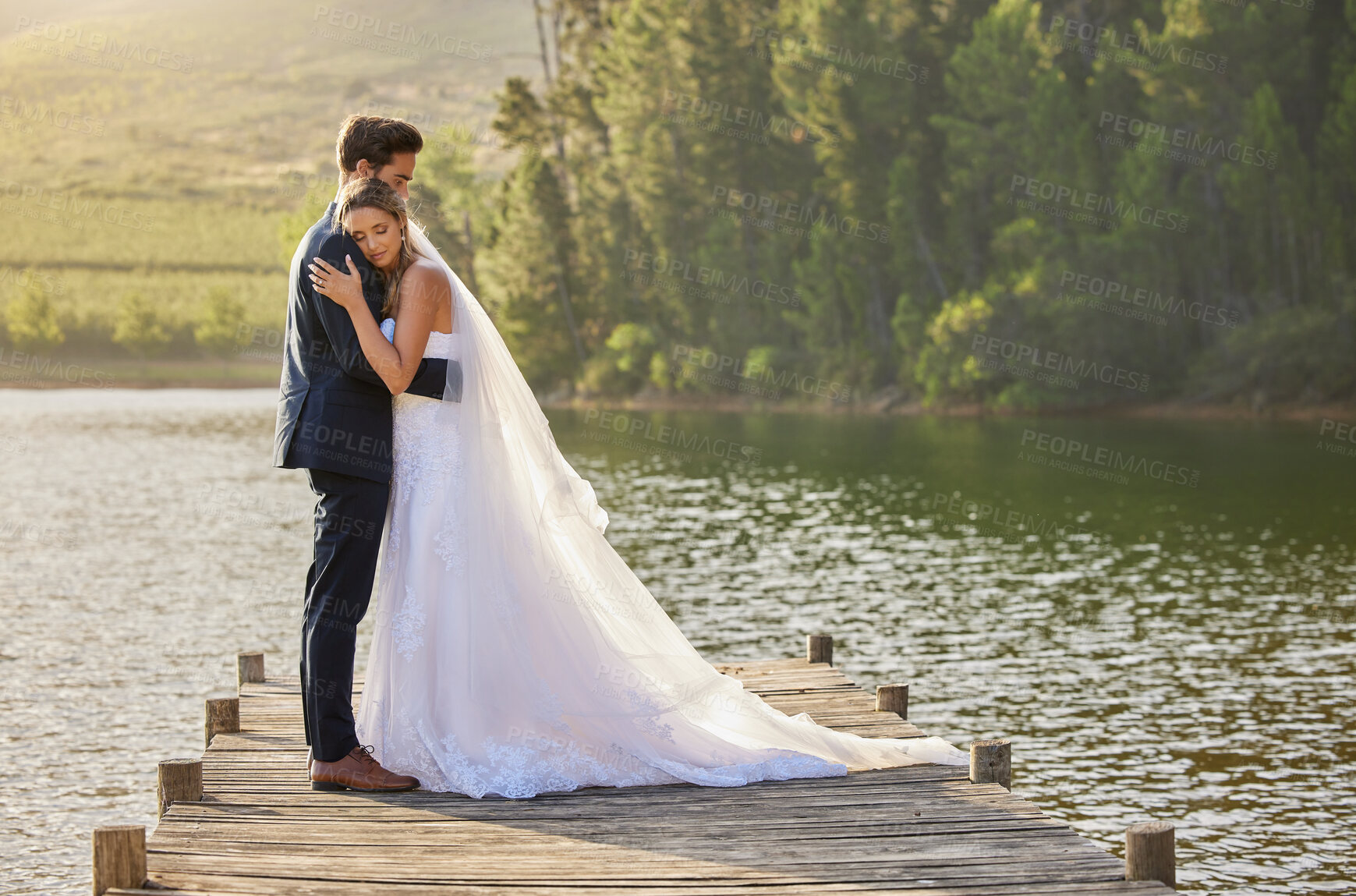 Buy stock photo Wedding couple, hug and love by lake in nature for relax or romantic honeymoon getaway. Calm woman hugging man in happy marriage relaxing by water together enjoying the loving embrace outdoors