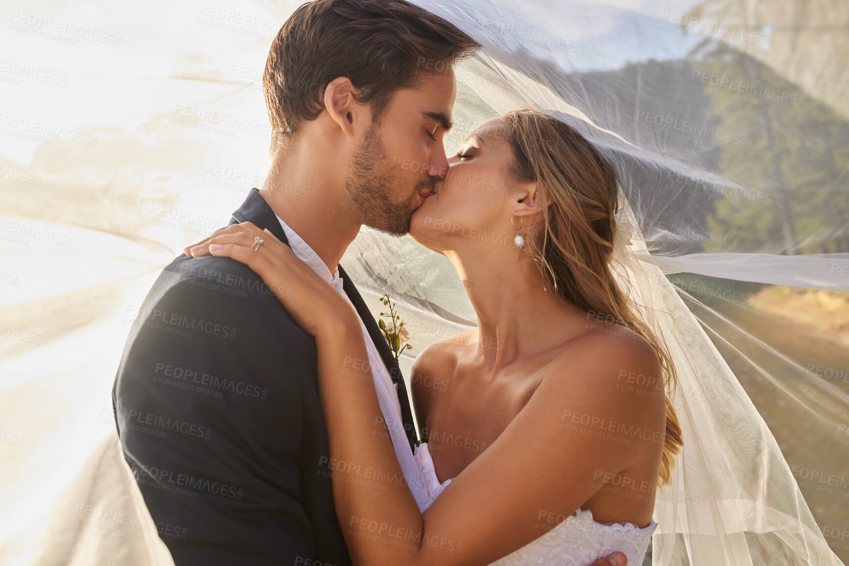 Buy stock photo Couple, wedding and kissing with vail for love, compassion or affection together in nature. Married man kiss woman on lips, hugging in marriage, relationship or loving embrace for commitment outdoors