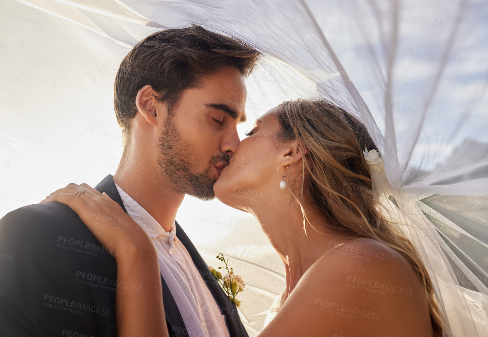Buy stock photo Couple, wedding and kiss with vail for love, compassion or affection together in nature. Married man kissing woman on lips, hugging in marriage, relationship or loving embrace for commitment outdoors