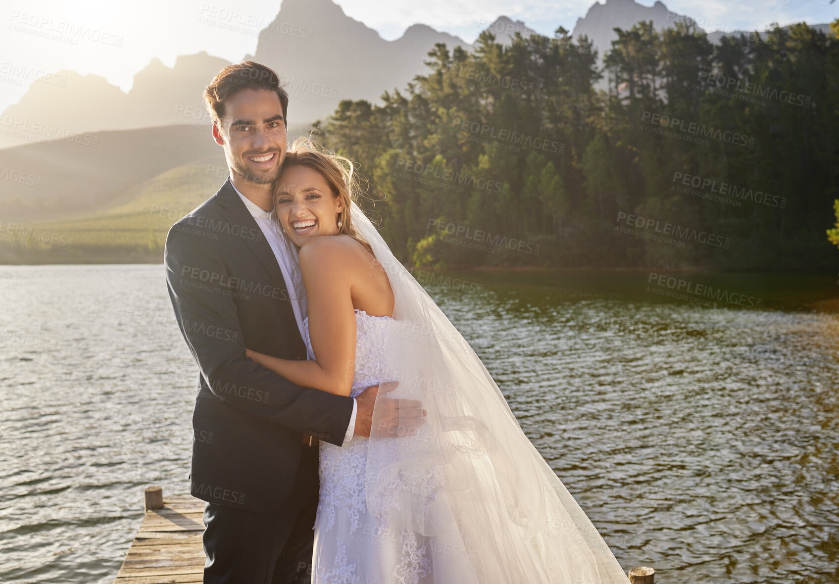 Buy stock photo Happy, hug and portrait of a married couple by a lake for a ceremony, celebration and marriage. Smile, affection and a bride and groom hugging after wedding and relationship commitment in nature