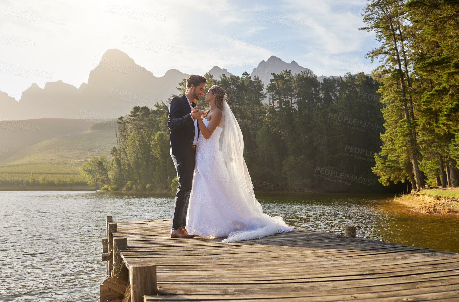 Buy stock photo Love, dance and a married couple on a pier over a lake in nature with a forest in the background after a ceremony. Wedding, romance or water with a bride and groom in celebration of marriage outdoor