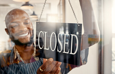 Buy stock photo Shot of a young business owner hanging up a closed for business sign