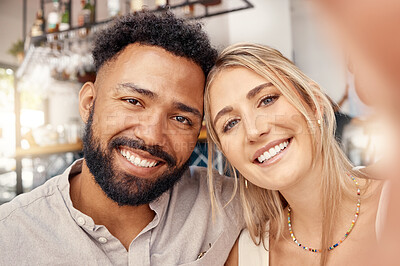 Buy stock photo Shot of two young friends taking selfies together at a restaurant