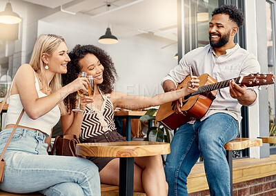 Buy stock photo Shot of two friends taking selfies together at a cafe while a man plays guitar