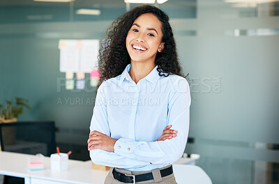 Buy stock photo Shot of an attractive young businesswoman standing alone in the office with her arms folded