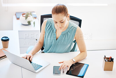 Buy stock photo Shot of an attractive young businesswoman sitting alone in the office and looking contemplative while using technology