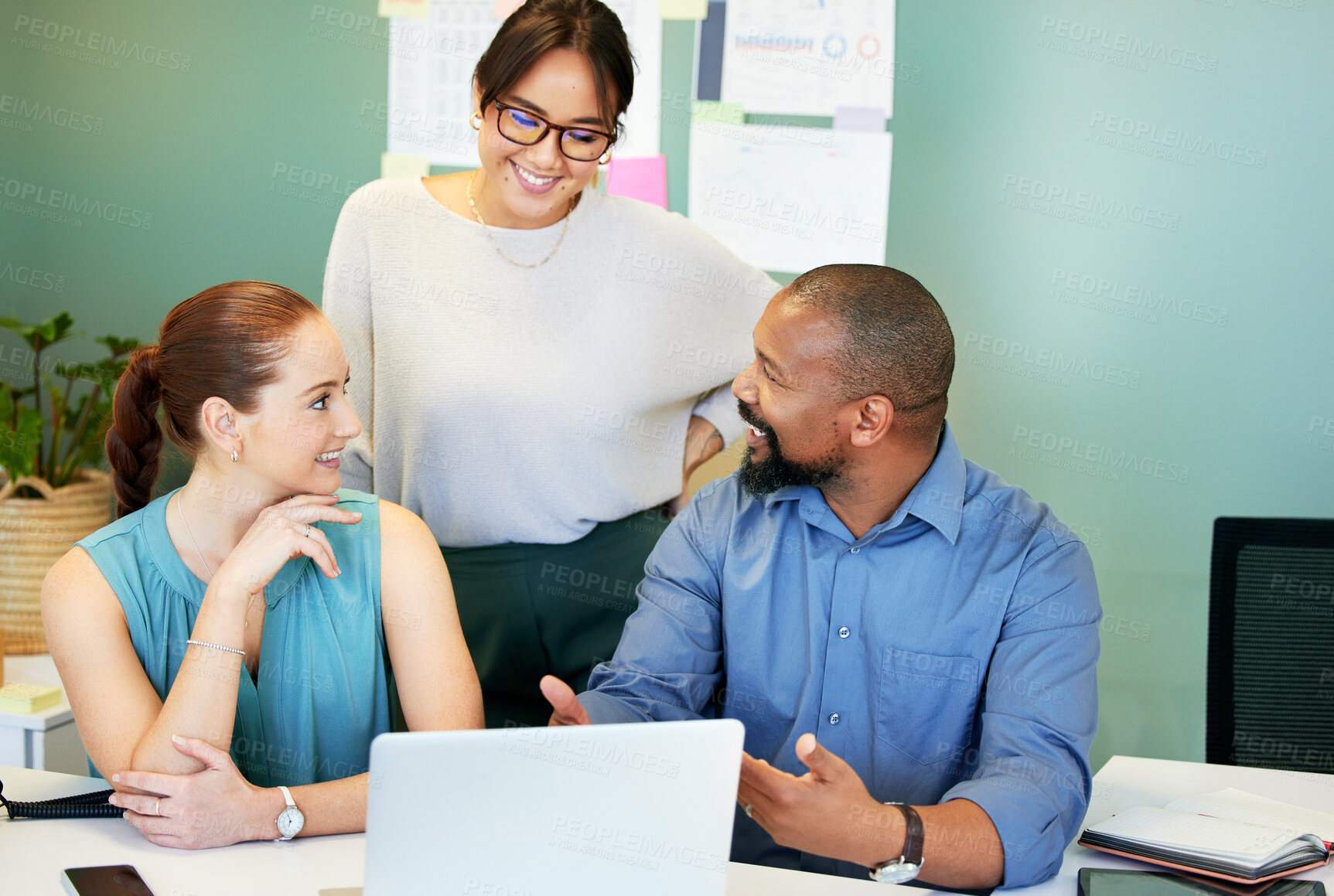 Buy stock photo Shot of a diverse group of businesspeople brainstorming while using a laptop in the office