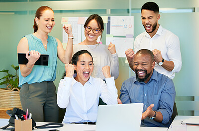 Buy stock photo Shot of a diverse group of businesspeople celebrating a success while using a laptop in the office