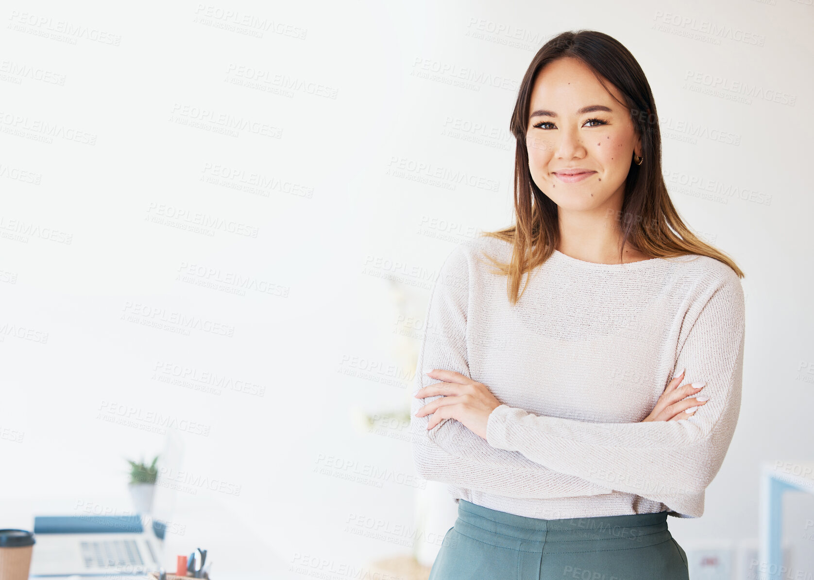 Buy stock photo Shot of an attractive young businesswoman standing alone in the office with her arms folded