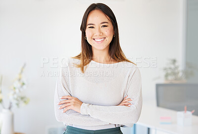 Buy stock photo Shot of an attractive young businesswoman standing alone in the office with her arms folded