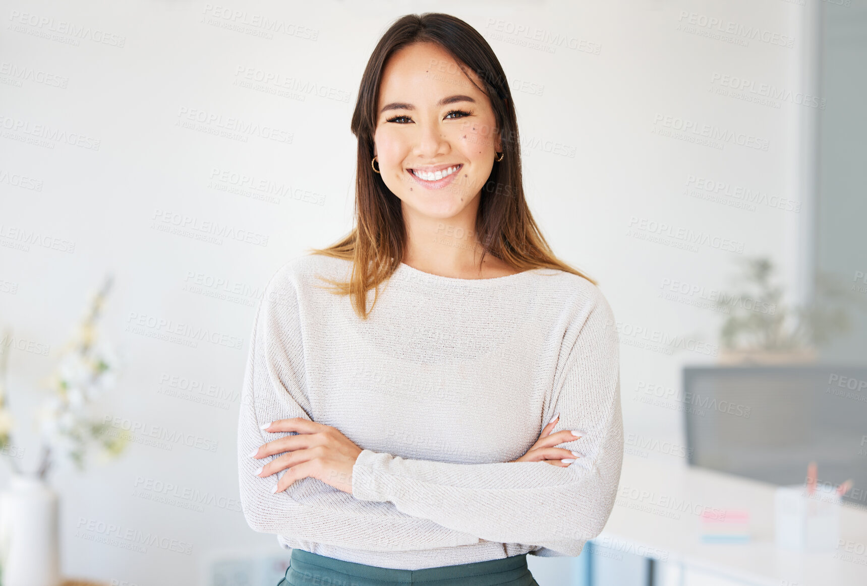 Buy stock photo Shot of an attractive young businesswoman standing alone in the office with her arms folded