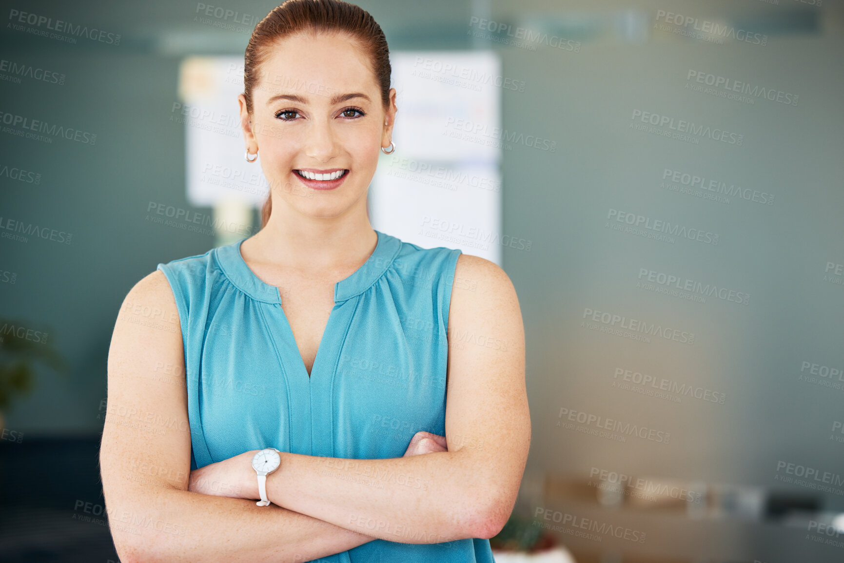 Buy stock photo Shot of an attractive young businesswoman standing alone in the office with her arms folded