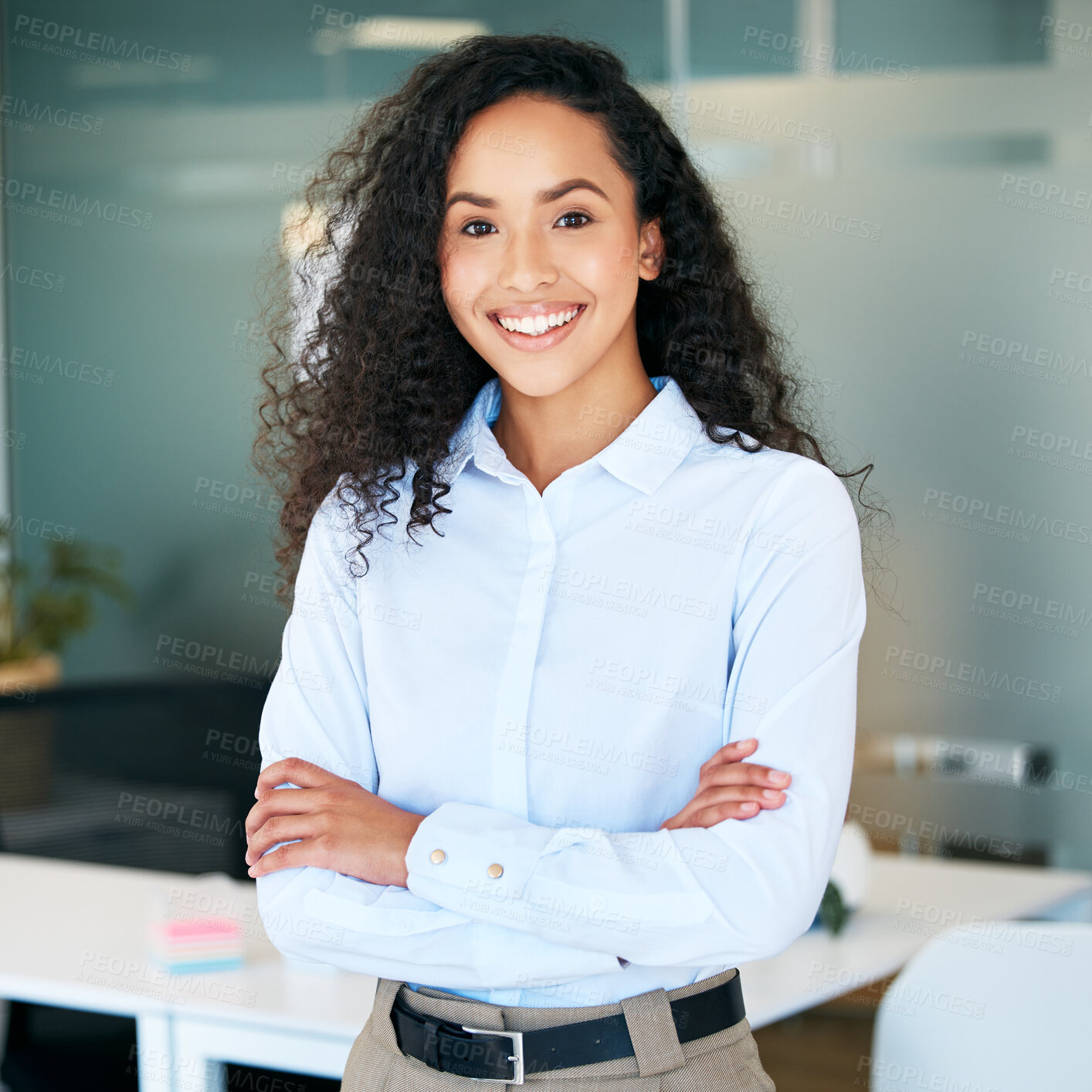 Buy stock photo Shot of an attractive young businesswoman standing alone in the office with her arms folded