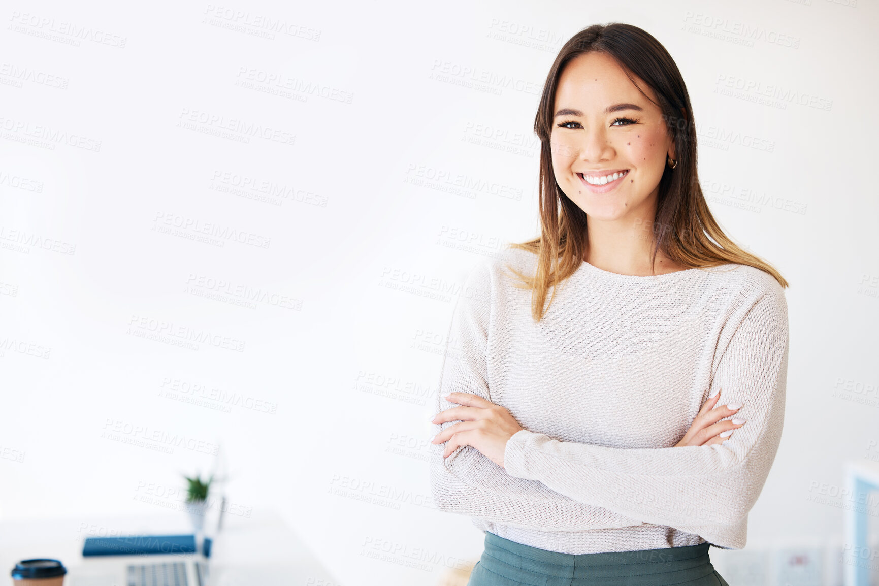 Buy stock photo Shot of an attractive young businesswoman standing alone in the office with her arms folded