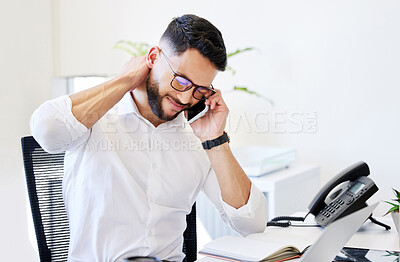 Buy stock photo Shot of a handsome young businessman sitting alone in the office and suffering from neck pain while using technology