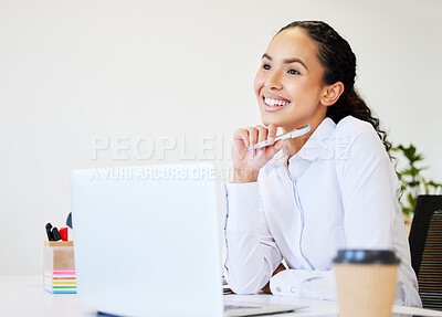 Buy stock photo Shot of an attractive young businesswoman sitting alone in the office and looking contemplative while using her laptop