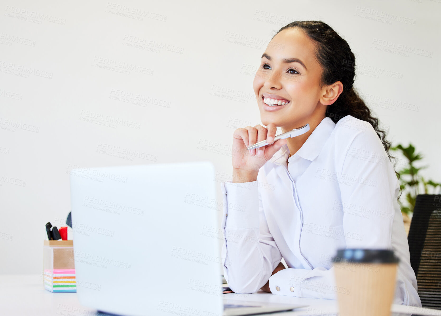 Buy stock photo Shot of an attractive young businesswoman sitting alone in the office and looking contemplative while using her laptop