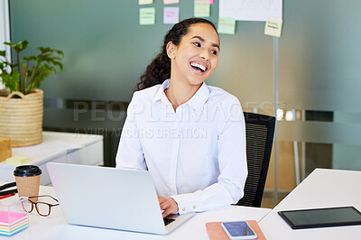 Buy stock photo Shot of an attractive young businesswoman sitting alone in the office and using her laptop