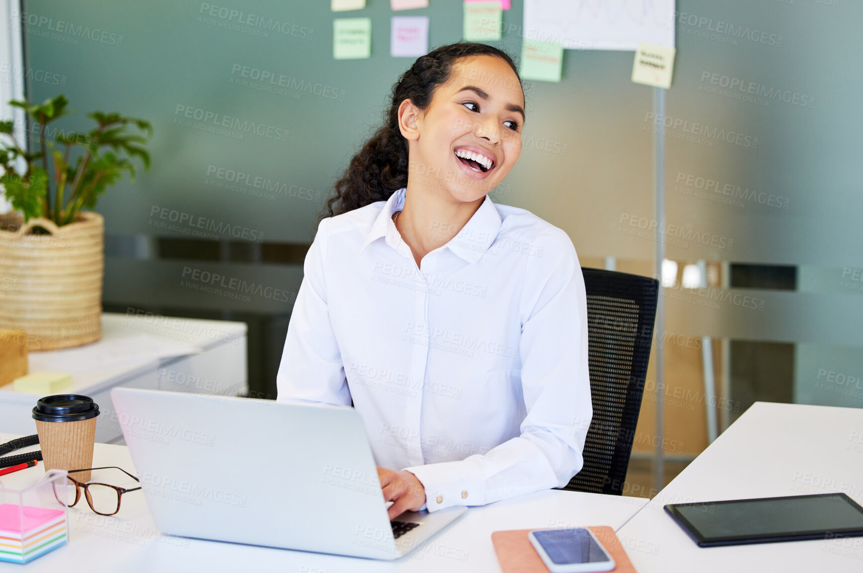 Buy stock photo Shot of an attractive young businesswoman sitting alone in the office and using her laptop