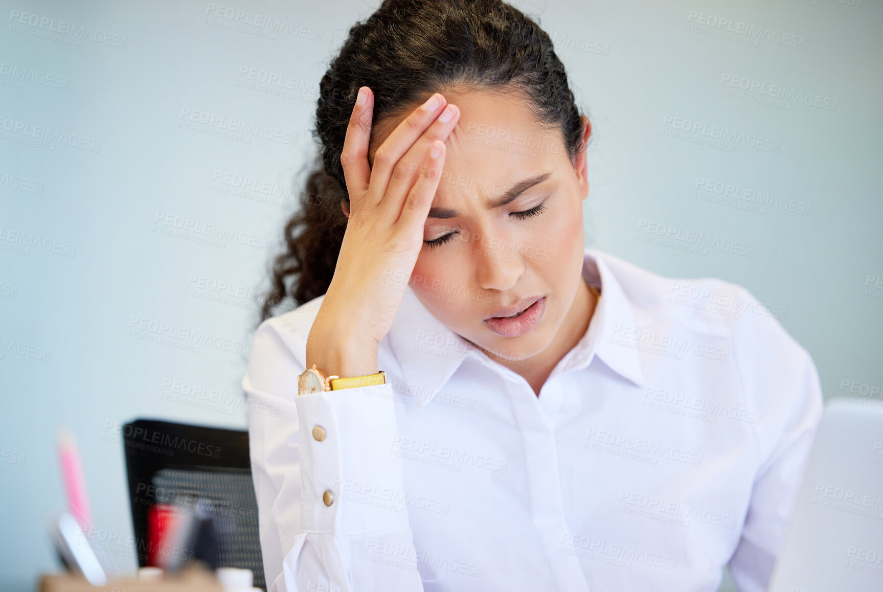 Buy stock photo Shot of an attractive young businesswoman sitting alone in the office and feeling stressed while using her laptop