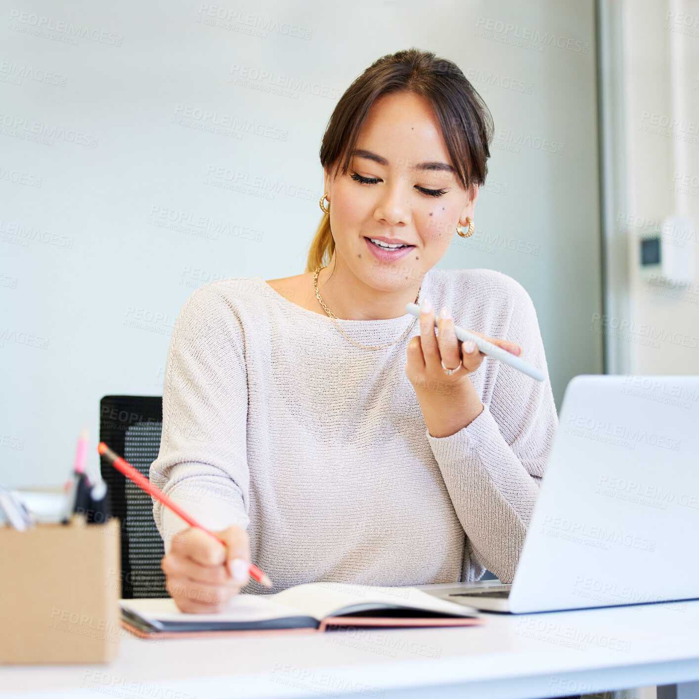 Buy stock photo Shot of an attractive young businesswoman sitting alone in the office and using her cellphone while writing notes