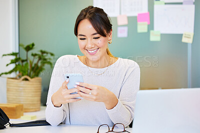 Buy stock photo Shot of an attractive young businesswoman sitting alone in the office and using her cellphone