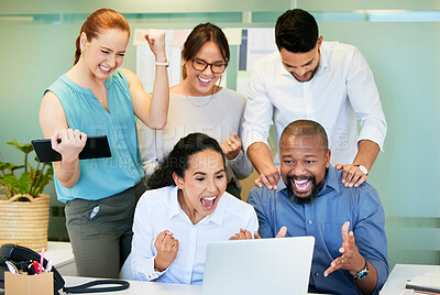 Buy stock photo Shot of a diverse group of businesspeople celebrating a success while using a laptop in the office