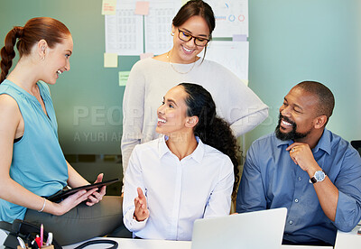 Buy stock photo Shot of a diverse group of businesspeople brainstorming while using a laptop in the office