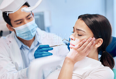 Buy stock photo Shot of a young woman looking scared in the dentists chair