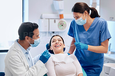 Buy stock photo Shot of a young male dentists getting ready to see his patient with his assistant