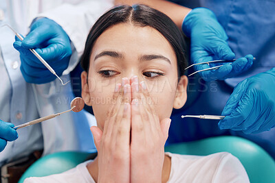 Buy stock photo Shot of a young woman covering her mouth in fear in her dentists office